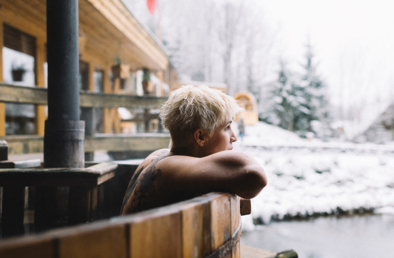 Frau schaut aus Whirlpool im Winter